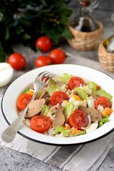 Cod liver salad with boiled eggs, cherry tomatoes, onions, lettuce and rice.