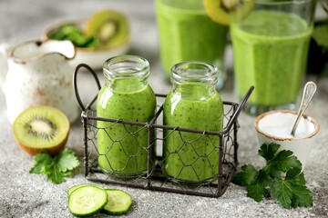 Healthy spinach, cucumber, kiwi, parsley smoothie with mineral water.