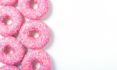 Left donuts border. Top view of yummy fresh homemade doughnuts. Light background for you text. 
