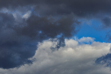 Dark storm clouds on a bright blue sky. Sky patterns background 2021.