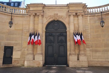 Portail d'entrée de l'hôtel de Matignon, palais de résidence officielle du Premier Ministre français, rue de Varenne à Paris, avec plusieurs drapeaux français (France) - obrazy, fototapety, plakaty