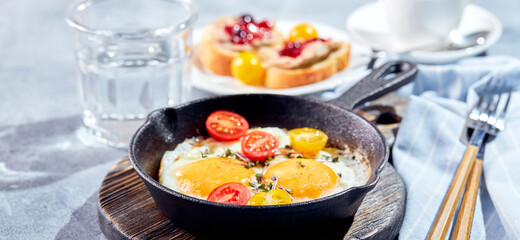 Fried eggs in cast-iron skillets. Sunny morning breakfast concept