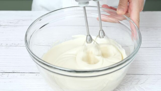 pastry chef use handmixer mixing meringue for cake and bakery.