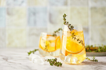 Refreshing cocktail with ice, orange and thyme. Refreshing summer homemade alcoholic or...