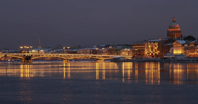 The panoramic footage of the winter night city Saint-Petersburg with picturesque reflection n water, Isaac cathedral on background, Blagoveshchensky bridge, old name is the lieutenant Schmidt