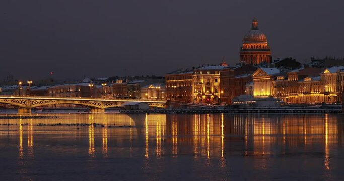The panoramic footage of the winter night city Saint-Petersburg with picturesque reflection n water, Isaac cathedral on background, Blagoveshchensky bridge, old name is the lieutenant Schmidt