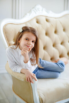 Little cute girl lies on the sofa in the room