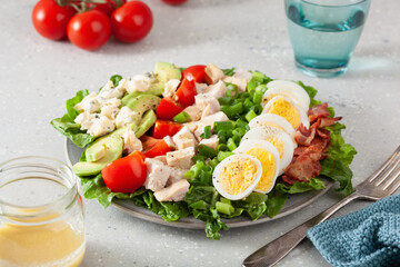 healthy American Cobb salad with egg bacon avocado chicken tomato. hearty keto low carb diet