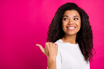Photo of excited brunette young lady point look empty space wear white t-shirt isolated on pink...