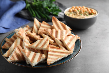 Delicious crispy pita chips on grey table