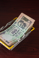 Hundred Indian rupee notes stacked in a shopping basket. Indian currency notes.