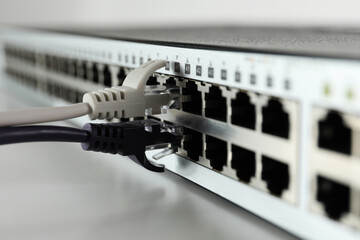 Closeup view of network switch with cables on light background. Internet connection