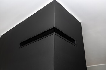 Hot air outlet in a modern fireplace with a closed combustion chamber standing in the living room,...