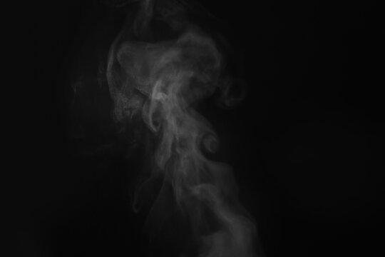 White steam in air against black background