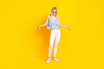 Full length photo of cheerful blond short hair lady wear spectacles top pants isolated on yellow color background