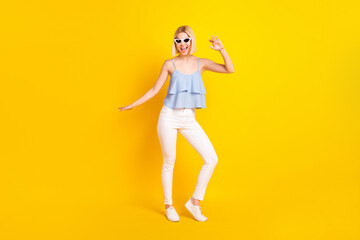 Fototapeta na wymiar Full length photo of funky blond short hair lady dance wear spectacles top pants isolated on yellow color background