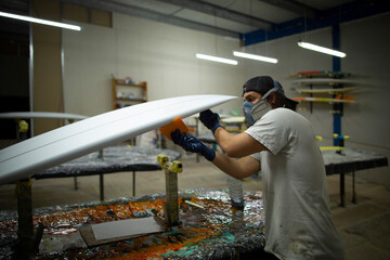 shaper modeling a new surf board