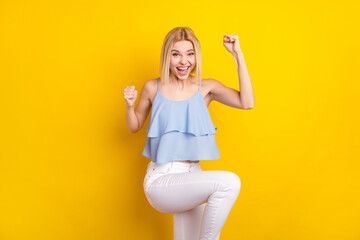 Photo of cheerful nice blond short hair lady hands fists yell wear blue top isolated on vivid...