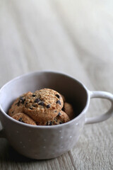 Bowl of chocolate chip cookies on wooden table. Selective focus.