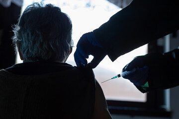 elderly woman receiving the vaccine at home