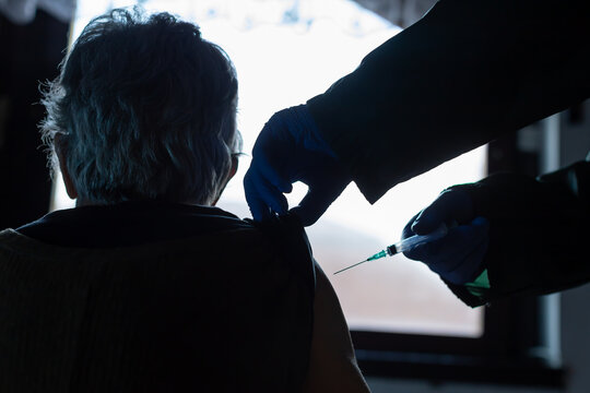 elderly woman receiving the vaccine at home