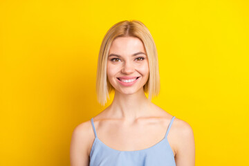 Photo of cheerful blond short hair lady wear blue top isolated on vivid yellow color background