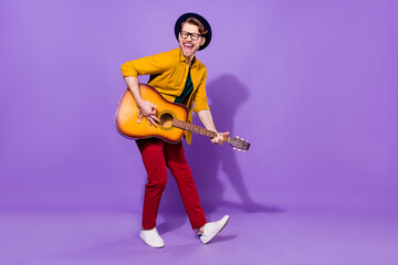 Fototapeta na wymiar Full size profile side photo of young guy happy positive smile play guitar artist isolated over purple color background