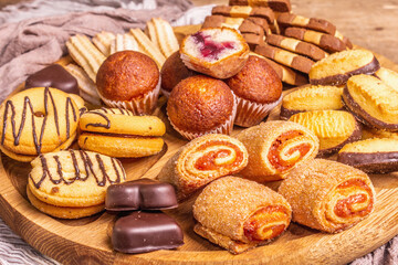 Assorted various cookies and muffins in wooden combination plate