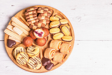 Assorted various cookies and muffins in wooden combination plate