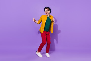 Full length photo of cheerful positive young man dance winner good mood isolated on violet color background