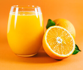 Glass of fresh orange juice with fruits cut in half and sliced with green leaf isolated on white background, clipping path