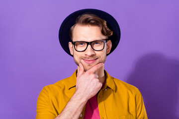 Photo of charming happy young minded man hold hand chin face think isolated on purple color...