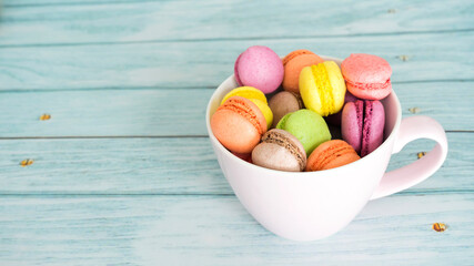 Cup of alcoholic macaroons on a wooden background. Pastel shades