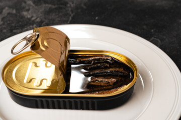 Open cans of canned fish on gray wooden table
