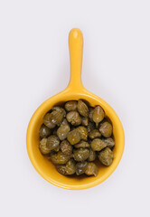 Small trial portion of pickled capers on platter isolated on white background. Design element with clipping path