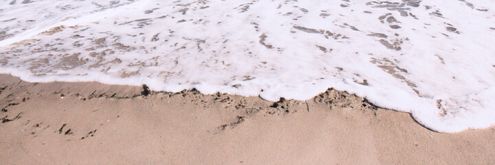 Deep blue ocean waves roll onto the sandy shore. Horizon of the sea. Banner