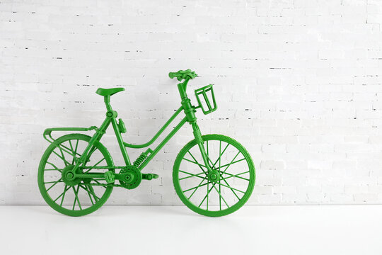 World bicycle day concept. Green bicykle on white brick wall. 3 june.