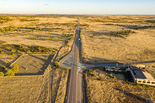 Aerial view of a straight road crossing the countryside at sunset near Fonfria, Zamora, Castilla y Leon, Spain.