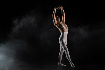 Naklejka na ściany i meble Male ballet dancer on a black background