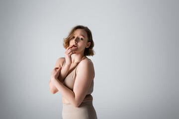Fototapeta premium overweight young woman in underwear posing on grey