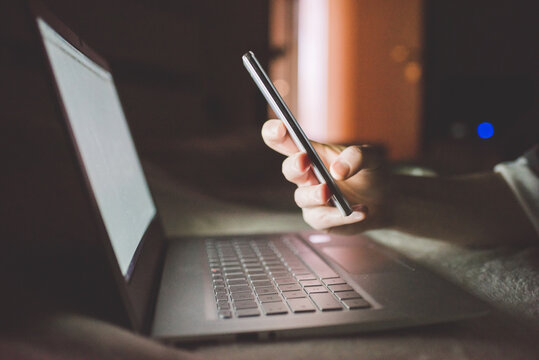 Close up woman hands using smartphone and computer