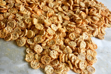 Popped Japanese brown rice is ground into powder, then made into a round disk, then crispy until golden brown and then dried. 