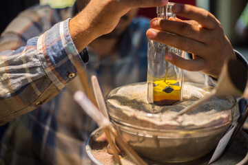 Making camel by sand in the souvenir sand bottle at the Madinat Jumeirah Souk, Dubai, UAE. Craftsman makes souvenirs in a bottle using colored sand