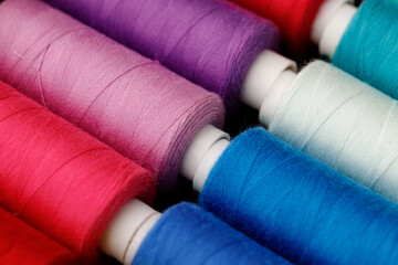 Close up of colored thread coils, thread spools background