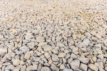 Various irregularly shaped, compacted stones as the basis for future asphalt pavement