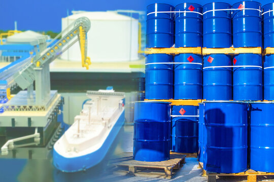 Blue barrels are stored in seaport. Blue barrels as a symbol of oil. Concept - oil from a tanker is poured into barrels. Crude oil is loaded onto ships. Concept - transit of petroleum products by sea