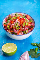 Homemade salsa pico de gallo, mexican cuisine, blue background