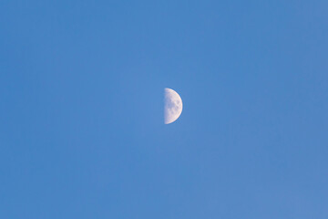 Half moon at clear blue sky in the day time.
