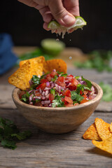 Man squeezes juice into salsa pico de gallo, mexican cuisine