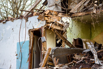 Demolition of an old two-story wooden house. Half destroyed building